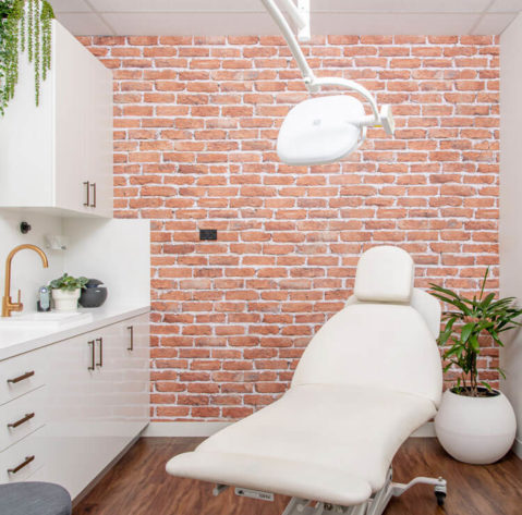 skinbox-clinic-consulting-room-white-with-brick-wall-and-consulting-bed