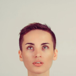 frontal view of person with gender-neutral facial features, looking upwards