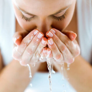 woman washing face with water